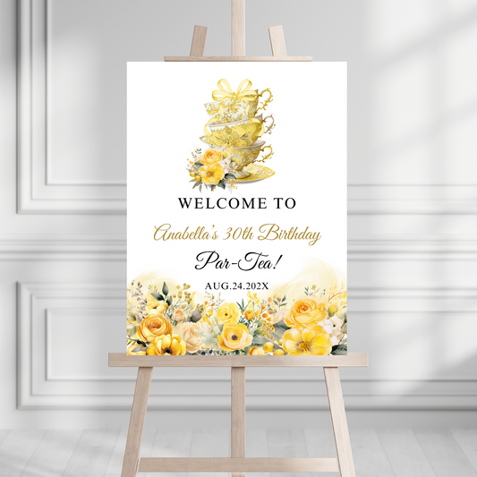 Decorative sign for a tea party birthday celebration with yellow flowers and teacups on an easel.