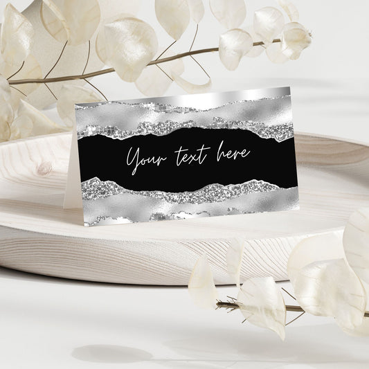 Decorative silver and black place card card with text placeholder against a floral background