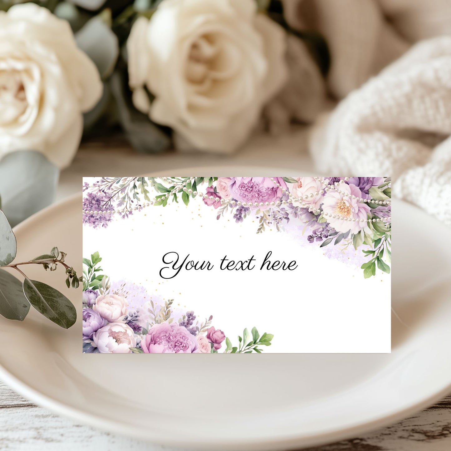 Purple floral and pearls card with placeholder text on a table with flowers