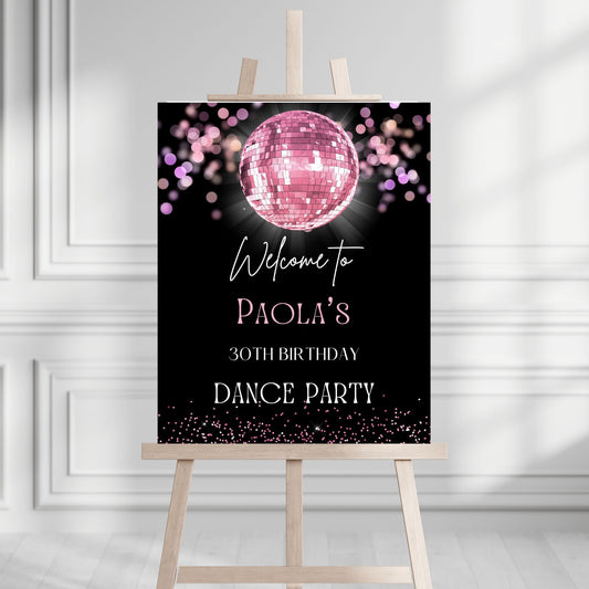 Party sign with pink disco ball and text on a stand against a white wall.