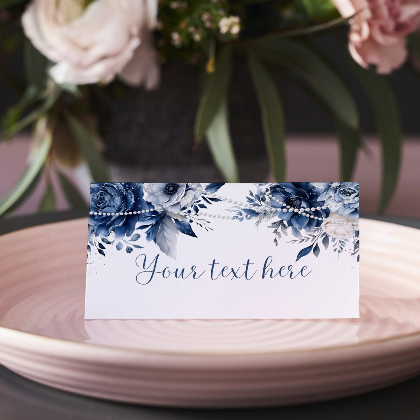 Blue Floral and pearls place card with 'Your text here' on a pink plate with flowers in the background