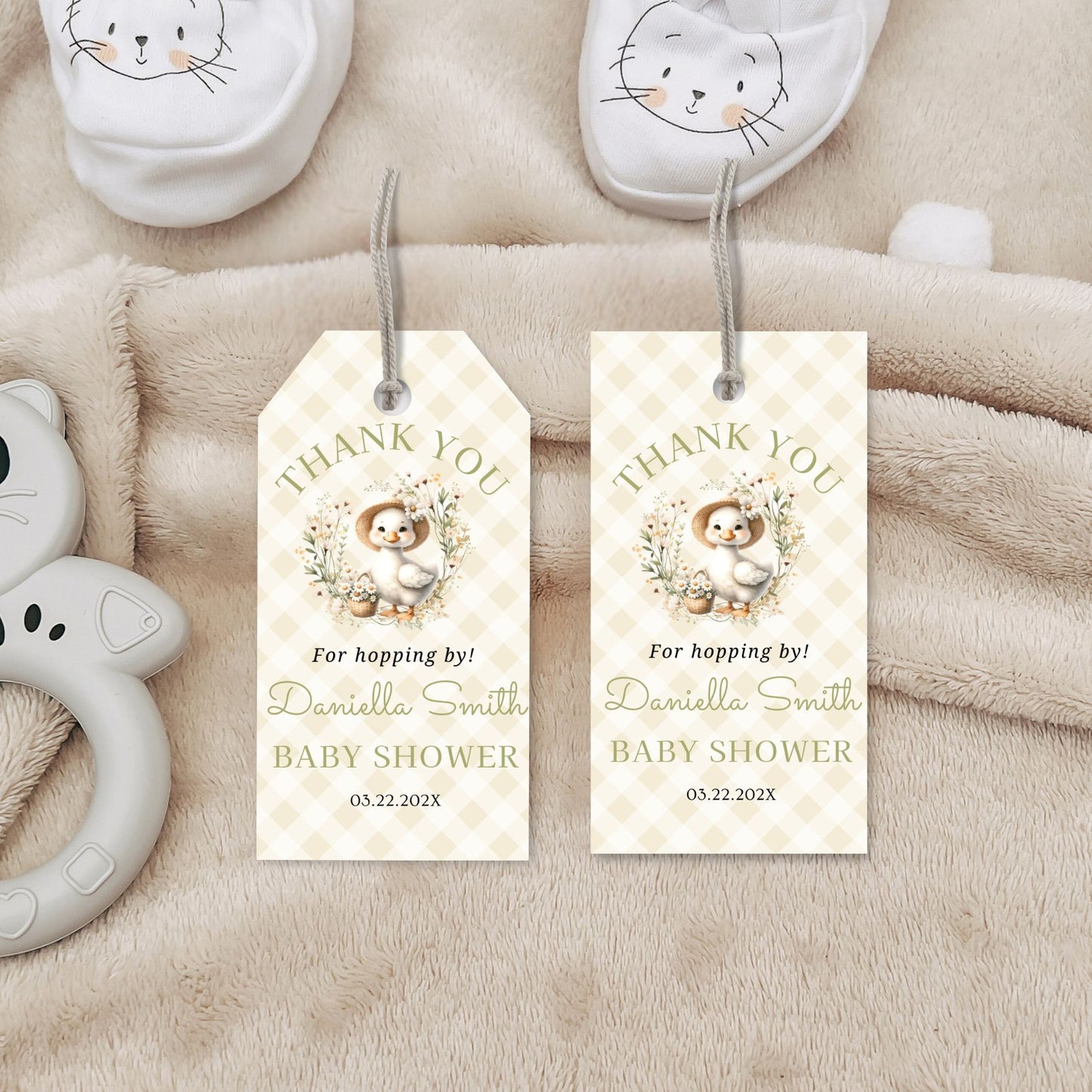 Baby shower favor tags with a baby animal illustration on a soft fabric background.