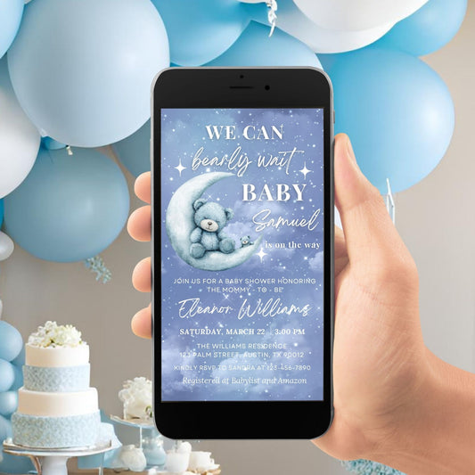 Hand holding a phone with a baby shower invitation on a background of blue and white balloons and a cake.