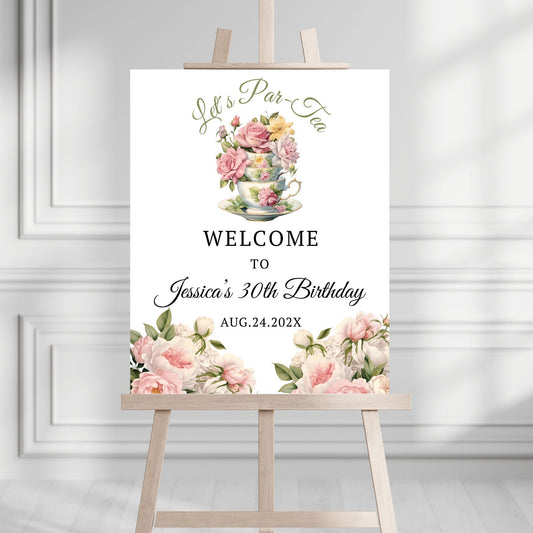 Decorative birthday sign with floral design and text on an easel against a white wall.