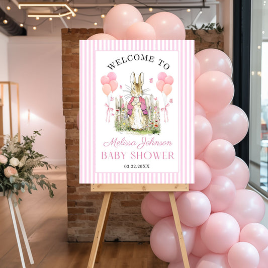 Peter Rabbit Baby shower welcome sign with pink balloons and floral decorations.