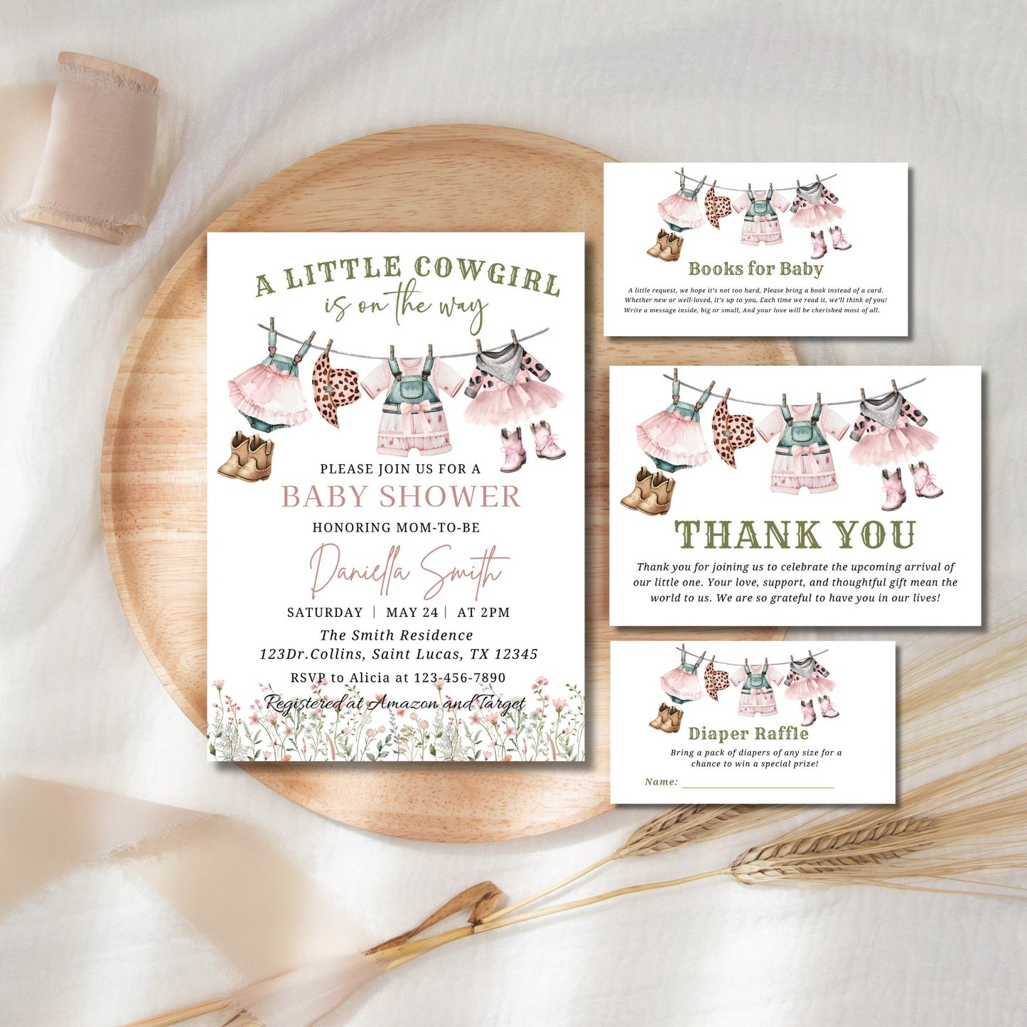 Baby shower invitation set with clothesline design on a wooden plate.