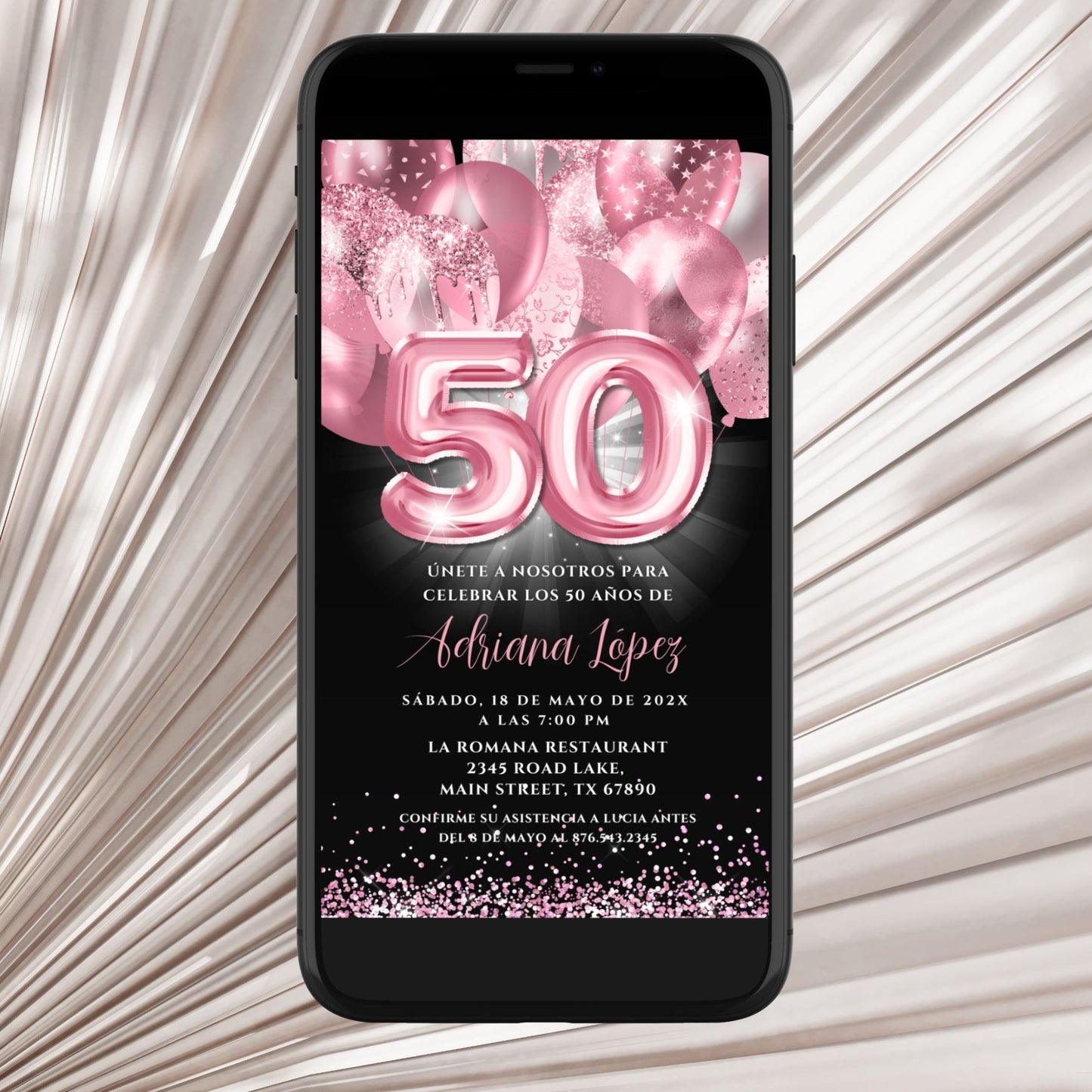 Phone displaying a birthday invitation with pink balloons and number '50' on a textured surface