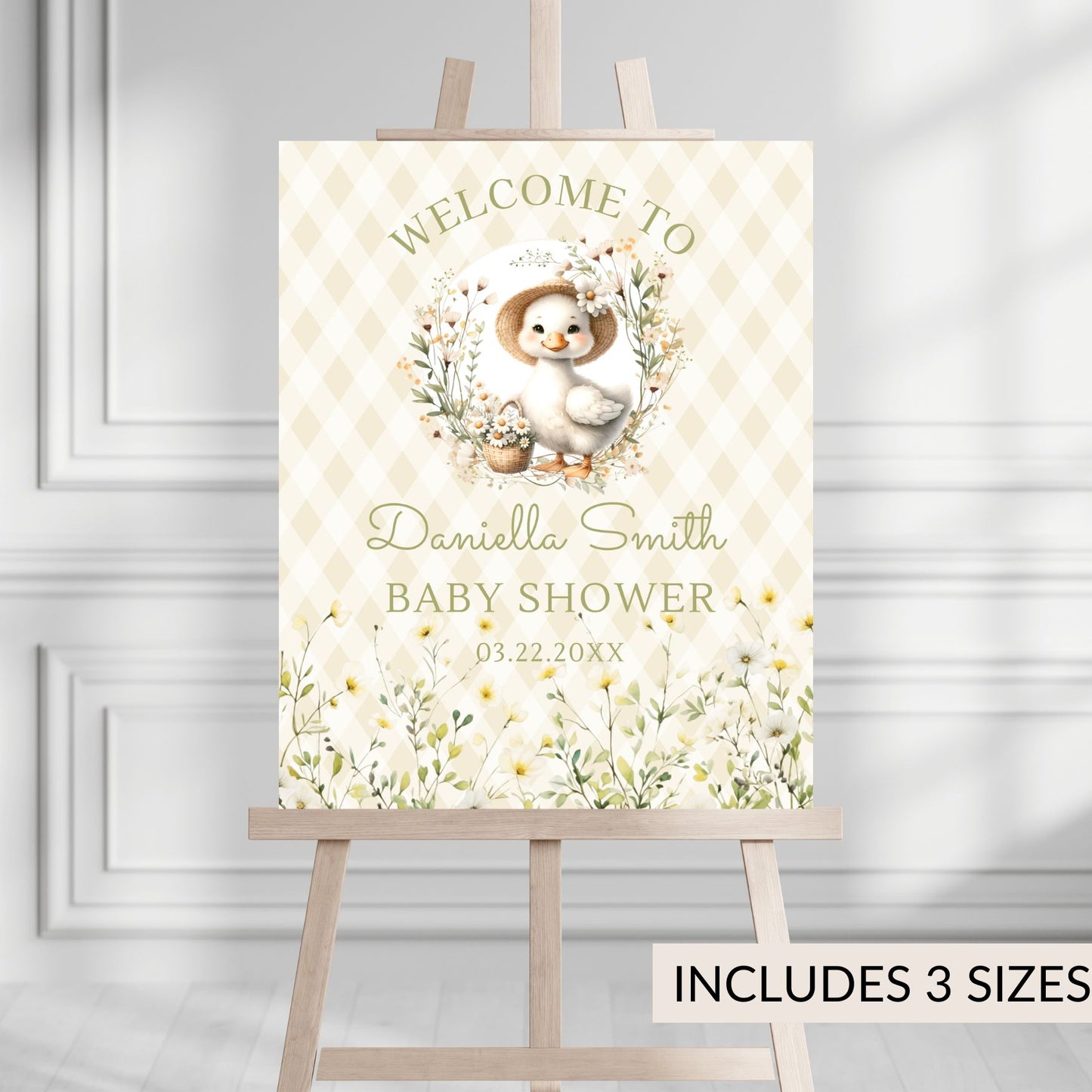 Baby shower welcome sign with a duck design on an easel against a gray wall.