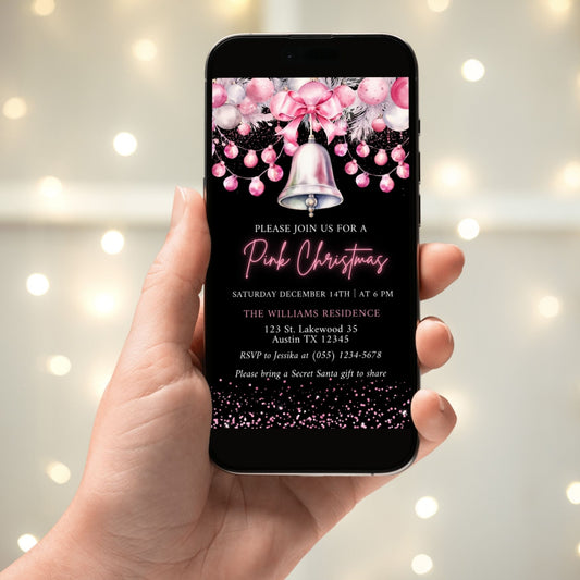 Hand holding a phone displaying a pink Christmas invitation with a bell and pink balloons.