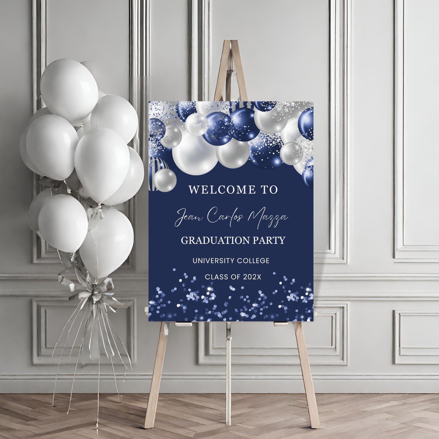 Graduation party welcome sign with balloons against a gray wall.