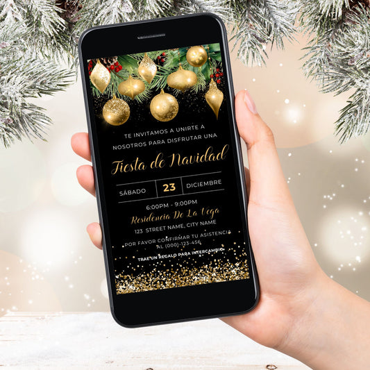 Hand holding a smartphone with a Gold Christmas invitation on the screen, surrounded by festive decorations.