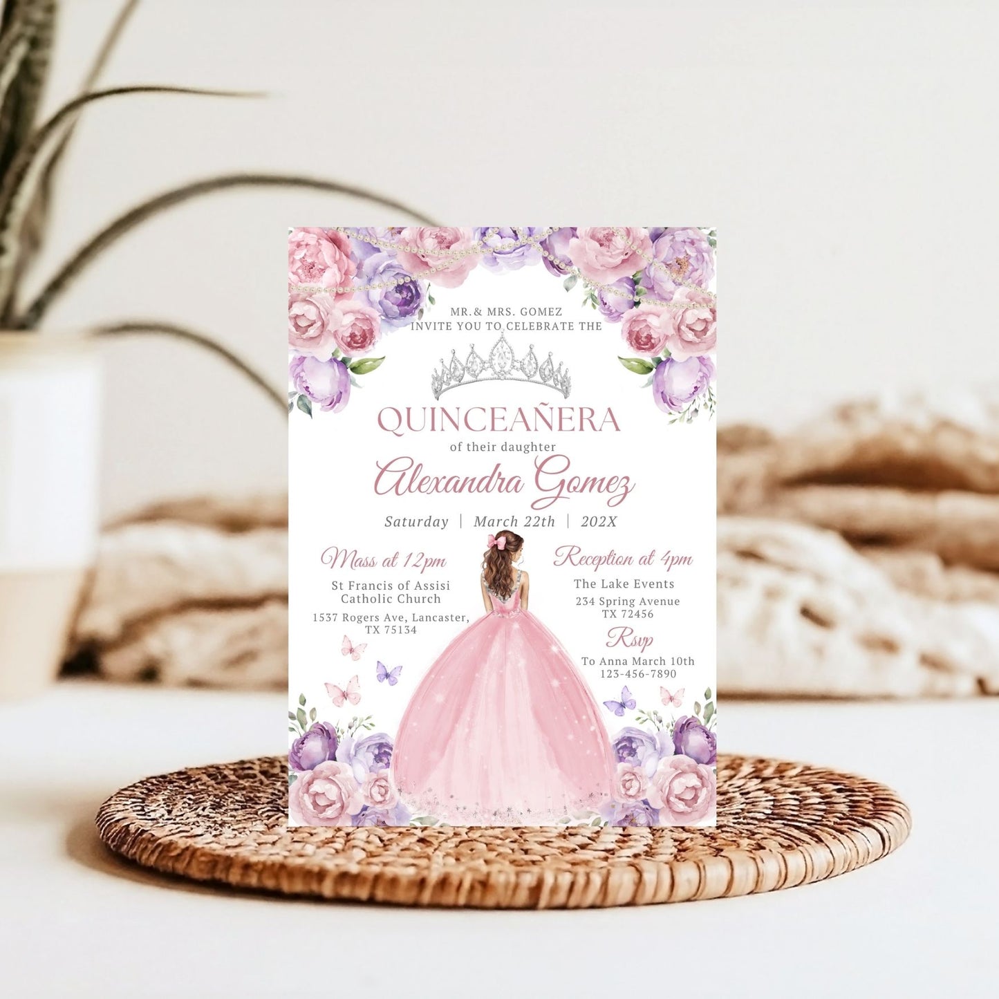 Quinceanera invitation card with floral design and pink dress on a woven mat.