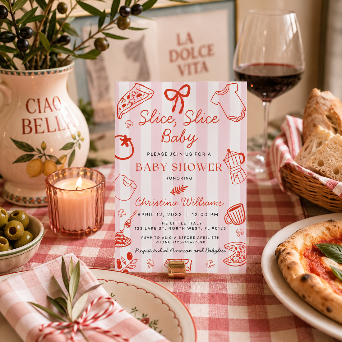 Italian pizza baby shower theme invitation displayed on a table with food, wine, and decor.