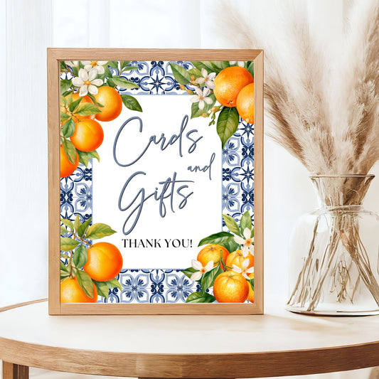 Framed artwork with decorative Cards and Gifts text and floral Orange elements on a table.