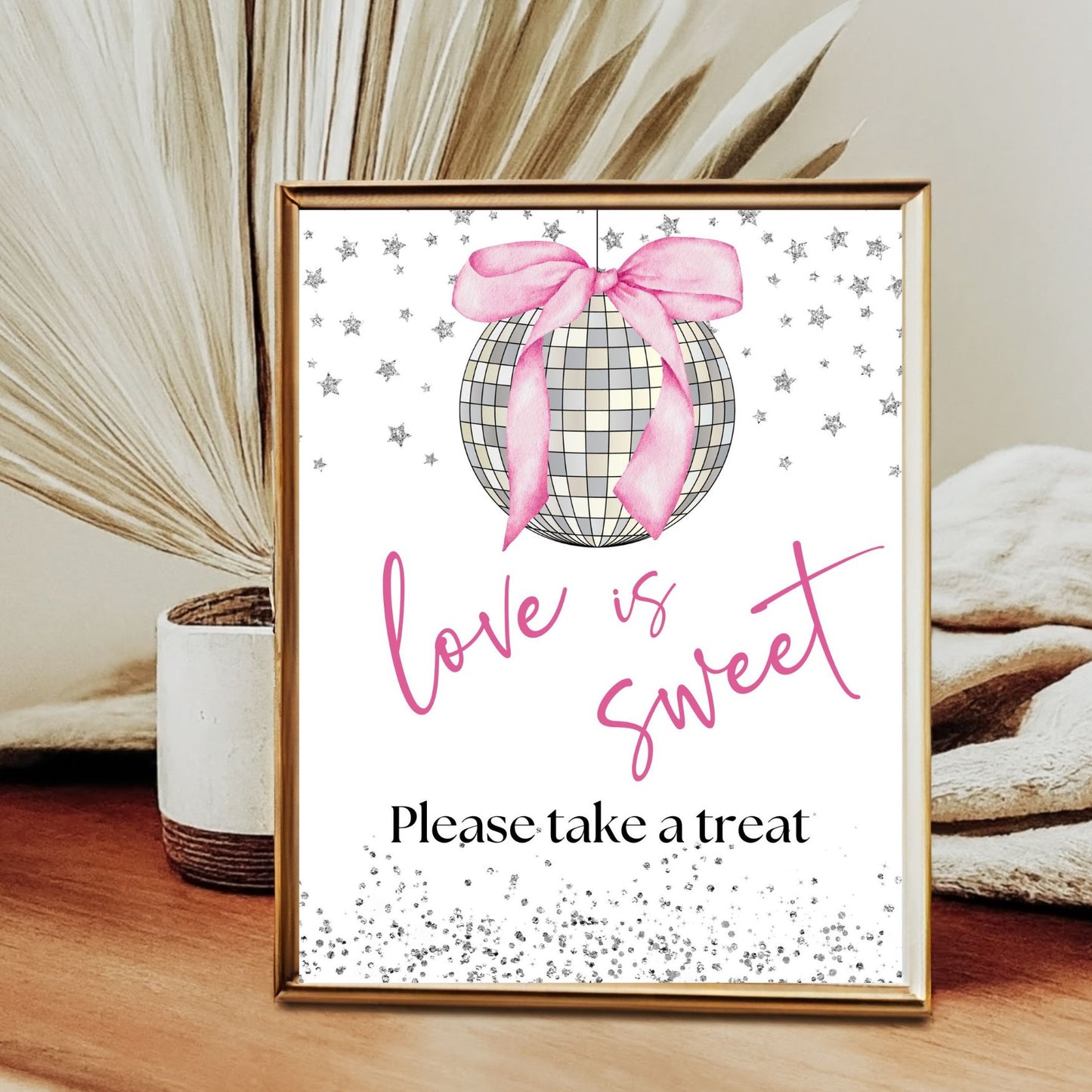 Framed decorative sign with a pink bow Disco ball and 'love is sweet' text on a wooden surface.