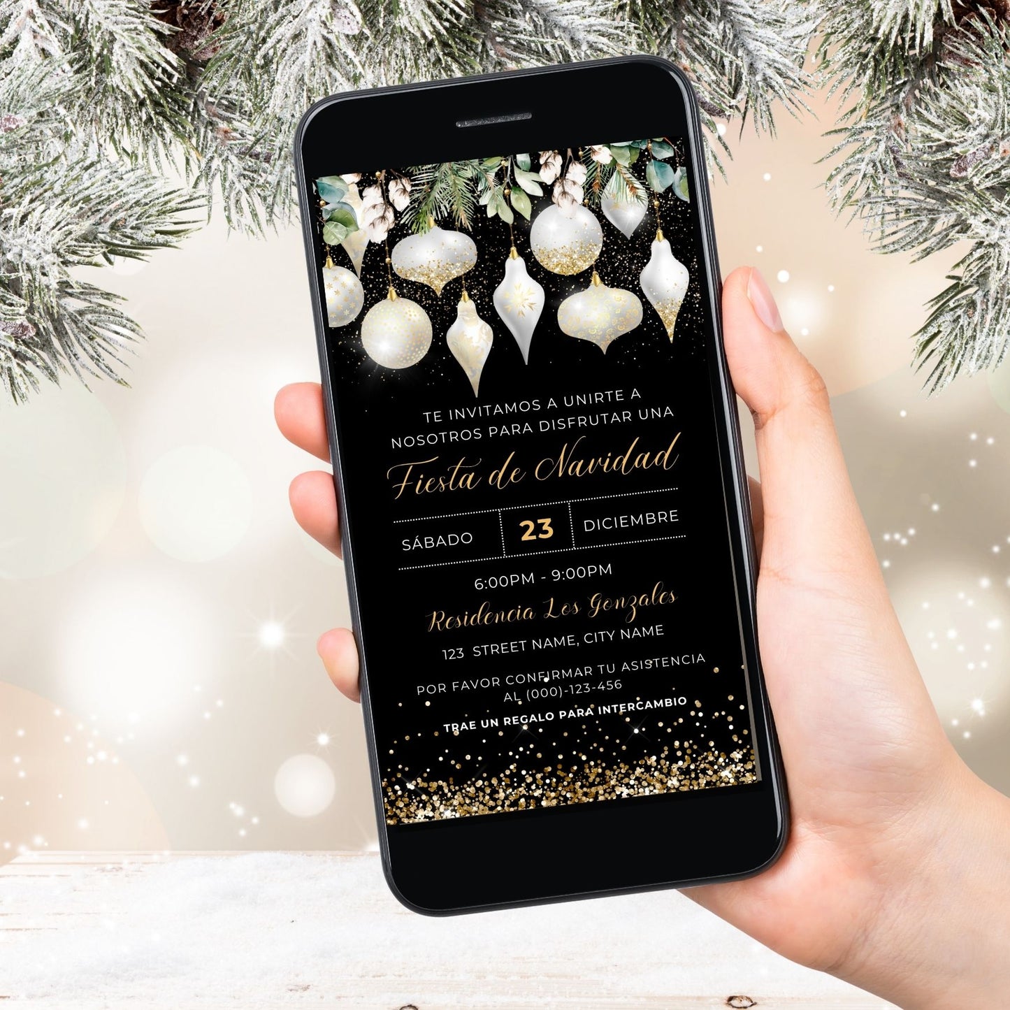 Hand holding a smartphone with a White and Gold Christmas invitation on the screen, surrounded by festive decorations.