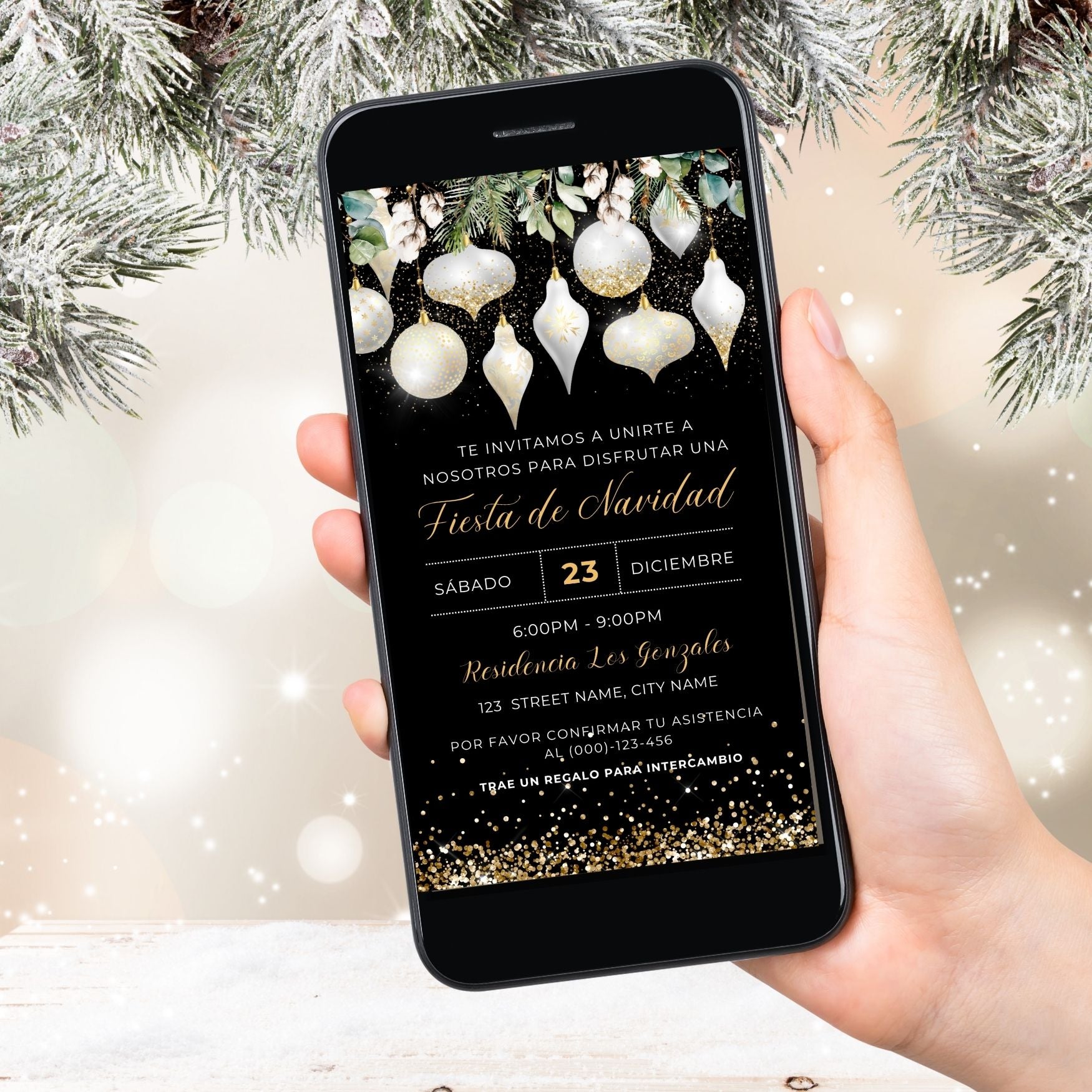 Hand holding a smartphone with a White and Gold Christmas invitation on the screen, surrounded by festive decorations.