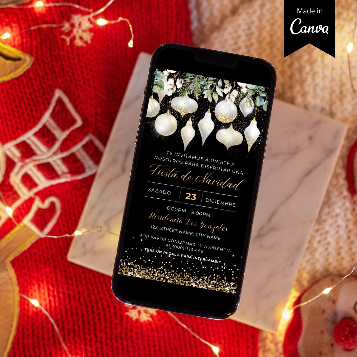Phone displaying a Spanish White Christmas invitation on a festive background with lights and a red fabric.