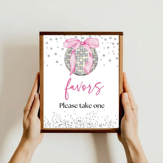 Framed sign with 'favors' and 'Please take one' text, held by hands against a light background. Printable Pink bow Disco ball sign.