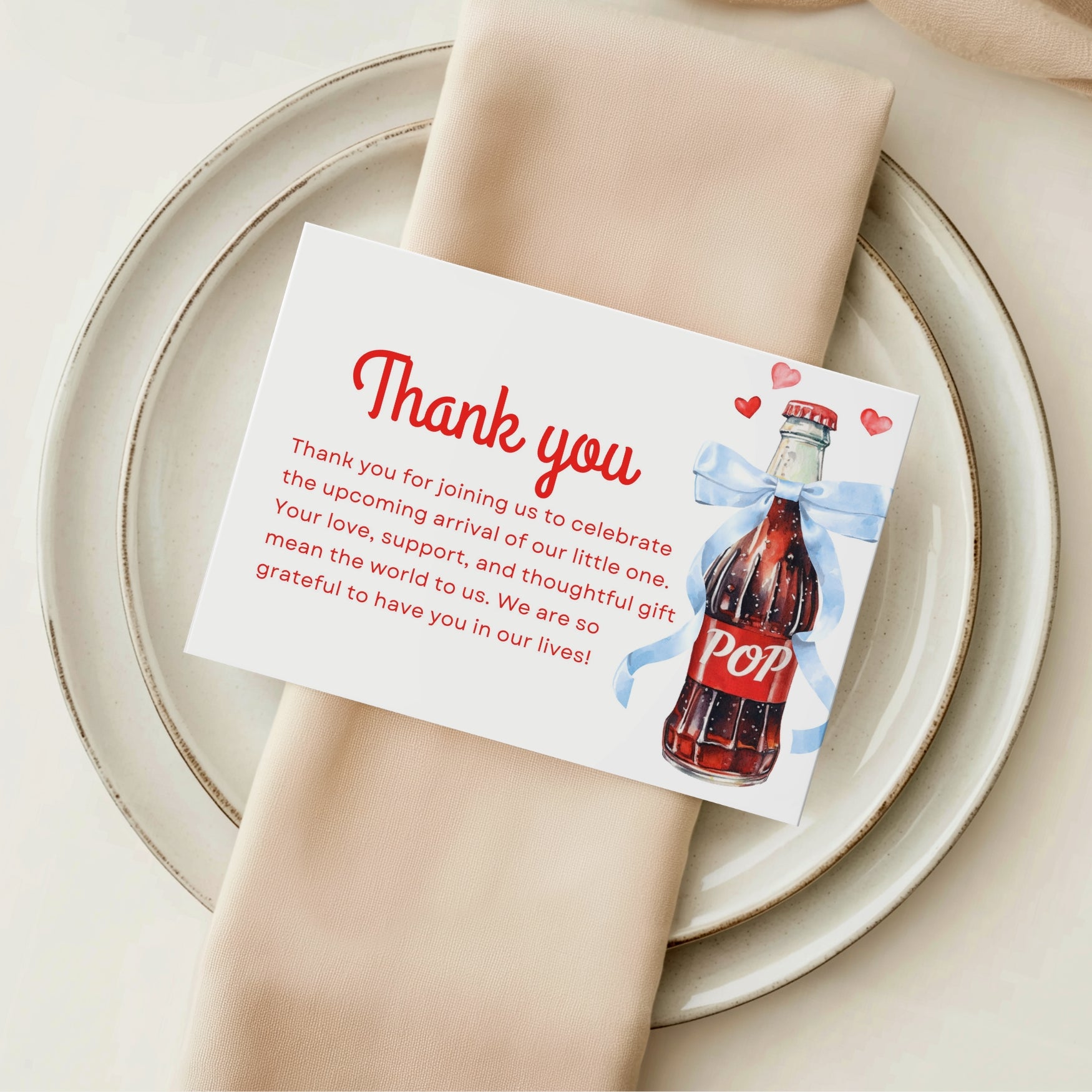 Thank you card from She’s Ready to Pop Baby Shower Invitation Bundle with soda bottle and ribbon on plate.