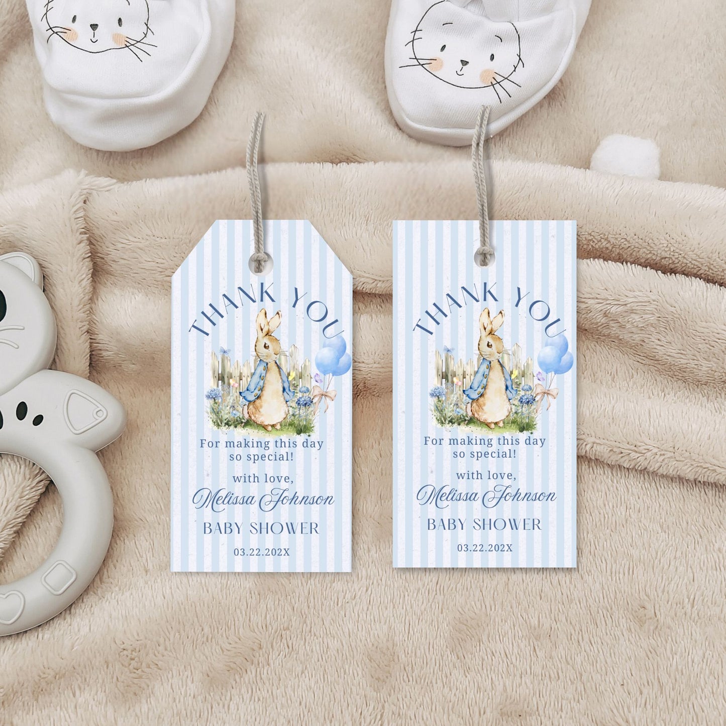 Two baby shower thank you tags with illustrations of a peter rabbit and text on a soft beige background.
