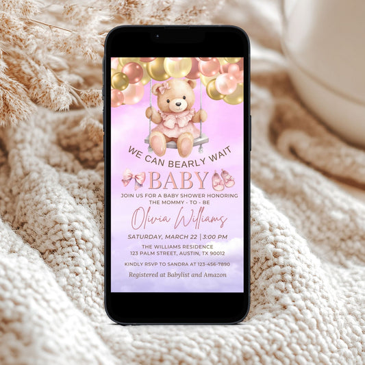 Phone displaying a baby shower invitation with a Pink teddy bear design on a textured surface