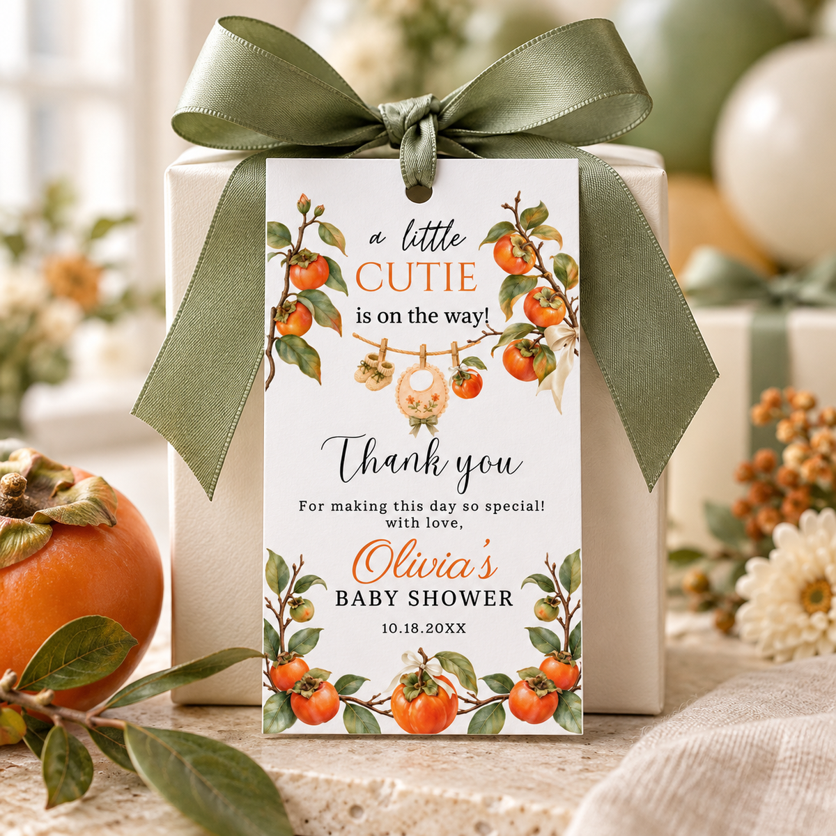 A Little Cutie Persimmon Baby Shower Thank You Gift Tag on a gift with green ribbon and botanical accents.