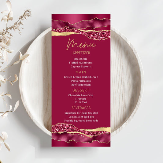 Menu card with a burgundy and gold design on a white plate