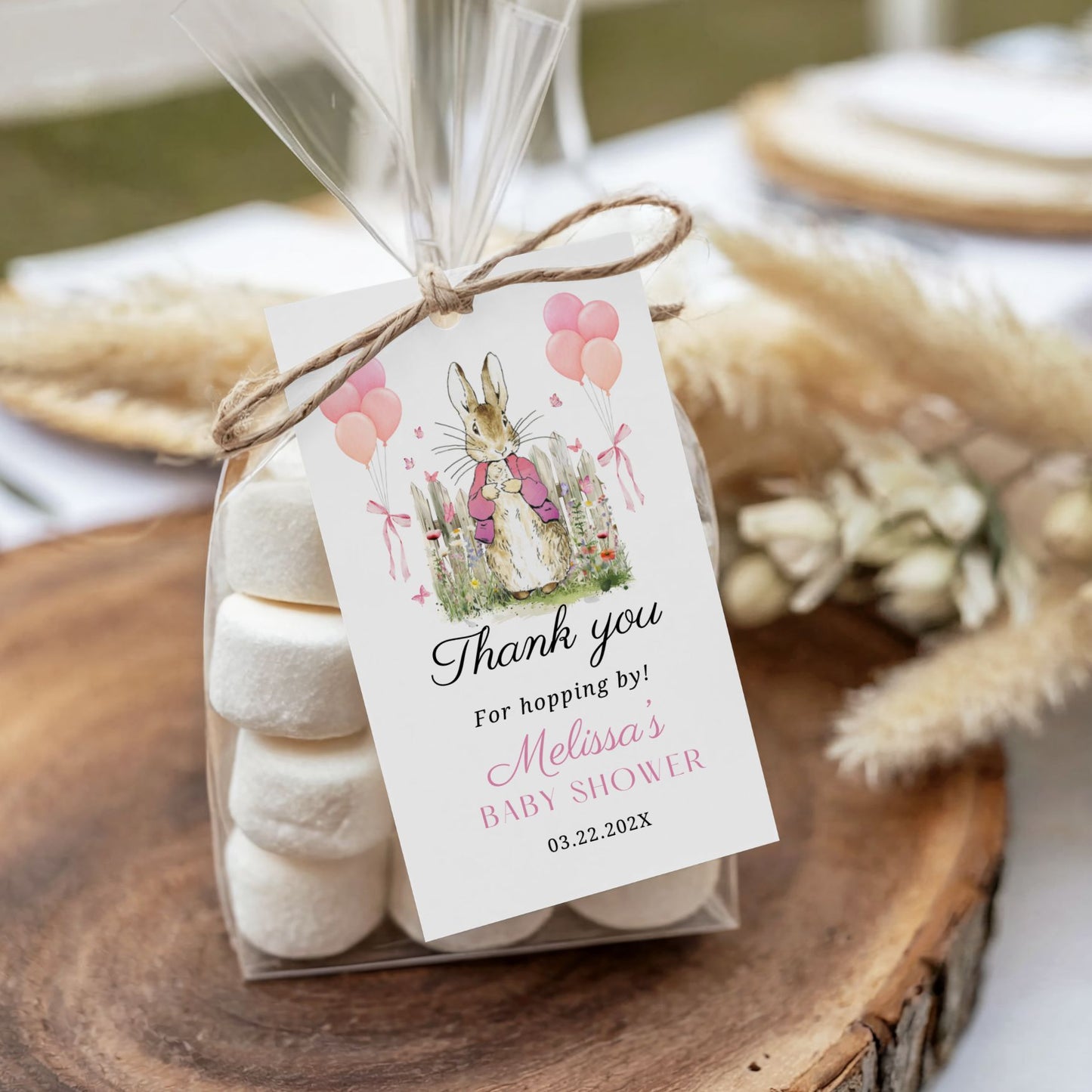 Box of marshmallows with a decorative tag for a Peter Rabbit baby shower on a wooden surface.
