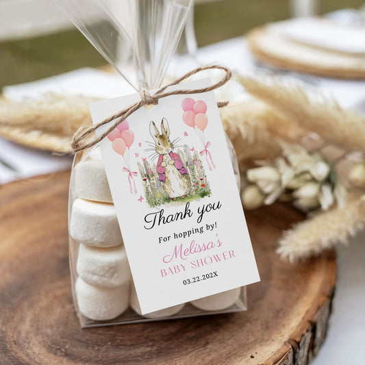 Box of marshmallows with a decorative tag for a Peter Rabbit baby shower on a wooden surface.