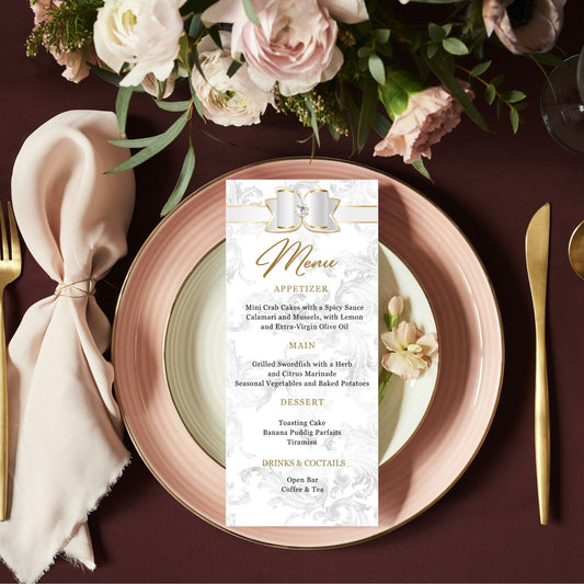 Table setting with a White and gold menu card, plates, and flowers on a dark surfaceite 