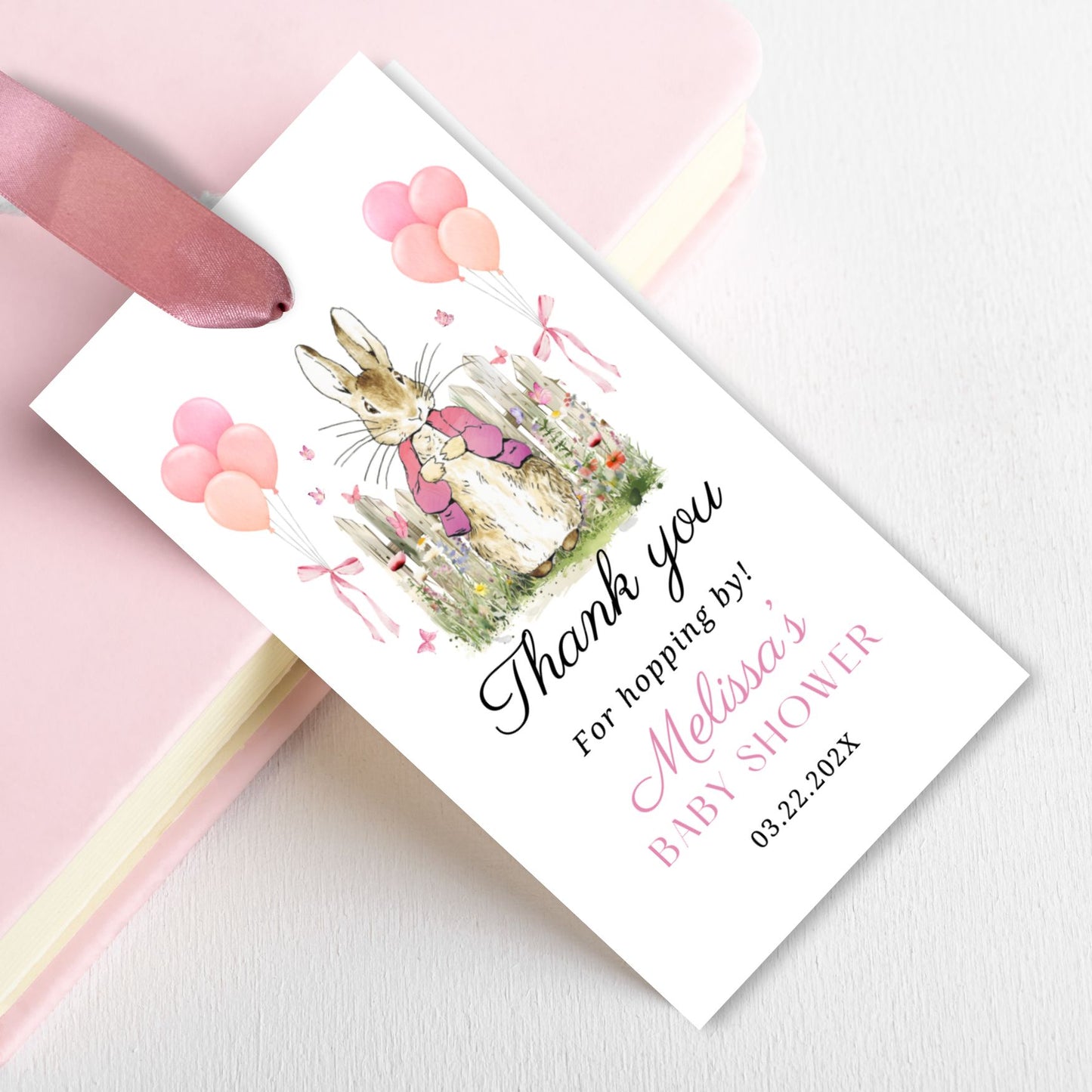 Baby shower favor tag with Pink Peter Rabbit bunny illustration and text on a pink background