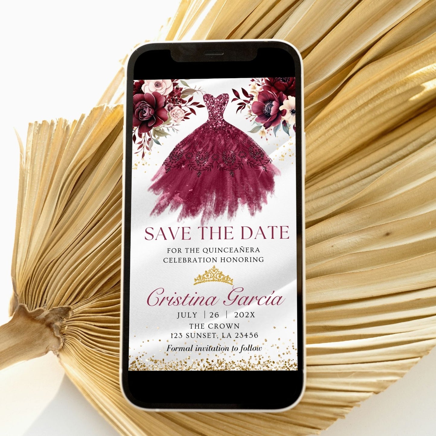 Phone displaying a quinceañera save the date invitation with a burgundy dress and flowers on a white background.