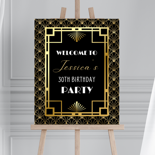 Decorative Art Deco birthday party sign with gold and black design on an easel against a gray background