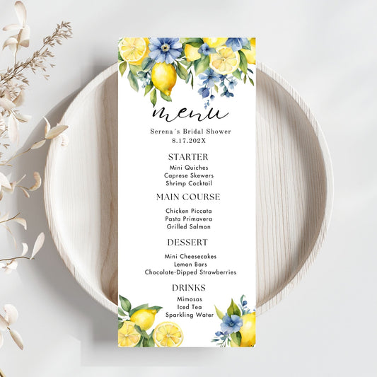 Menu card for a bridal shower with Blue floral and lemon design on a white plate.