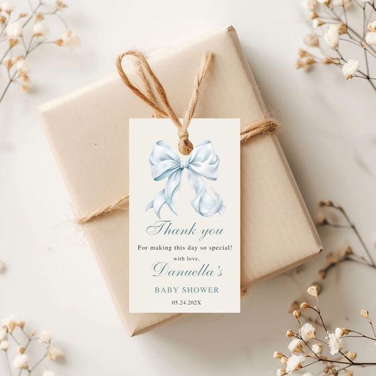 Gift box with a decorative tag featuring a Dusty blue bow on a light background.