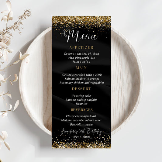 Black menu card with gold glitter text on a white plate with decorative elements.