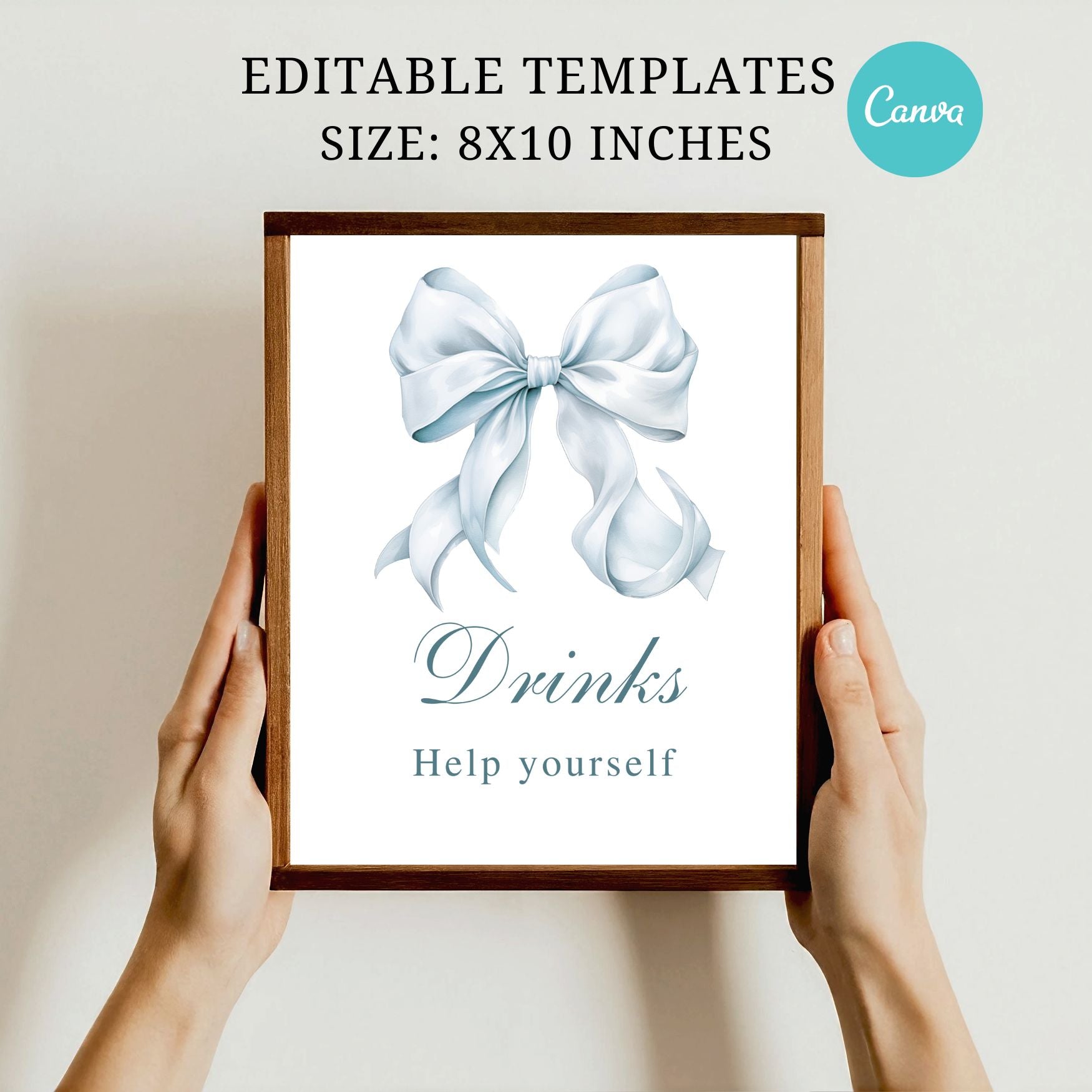 Framed sign with a blue bow and 'Drinks Help yourself' text, held by hands against a plain background.