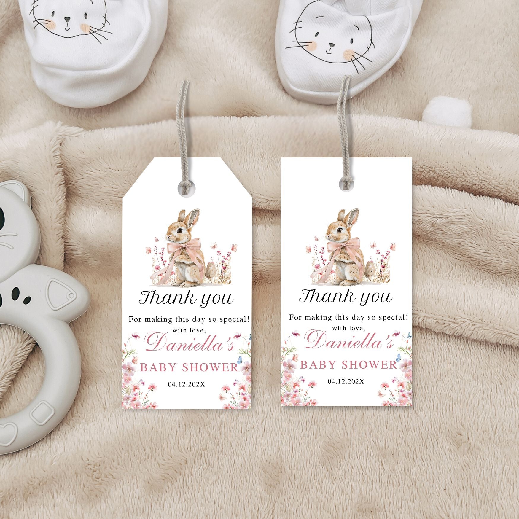 Two baby shower thank you tags with a rabbit illustration on a soft fabric background.