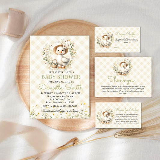 Baby shower invitation set with duck design on a wooden plate.