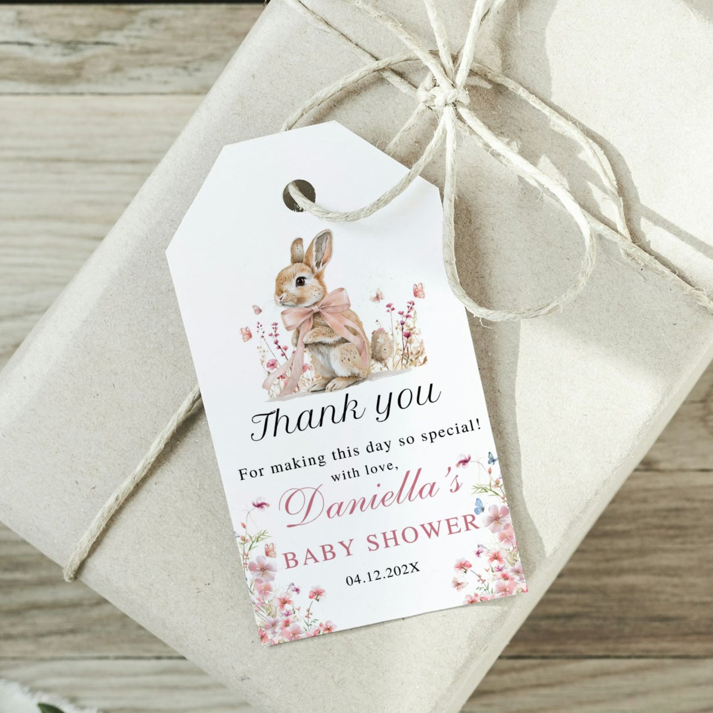 Gift tag with a rabbit illustration and baby shower message on a wrapped gift.