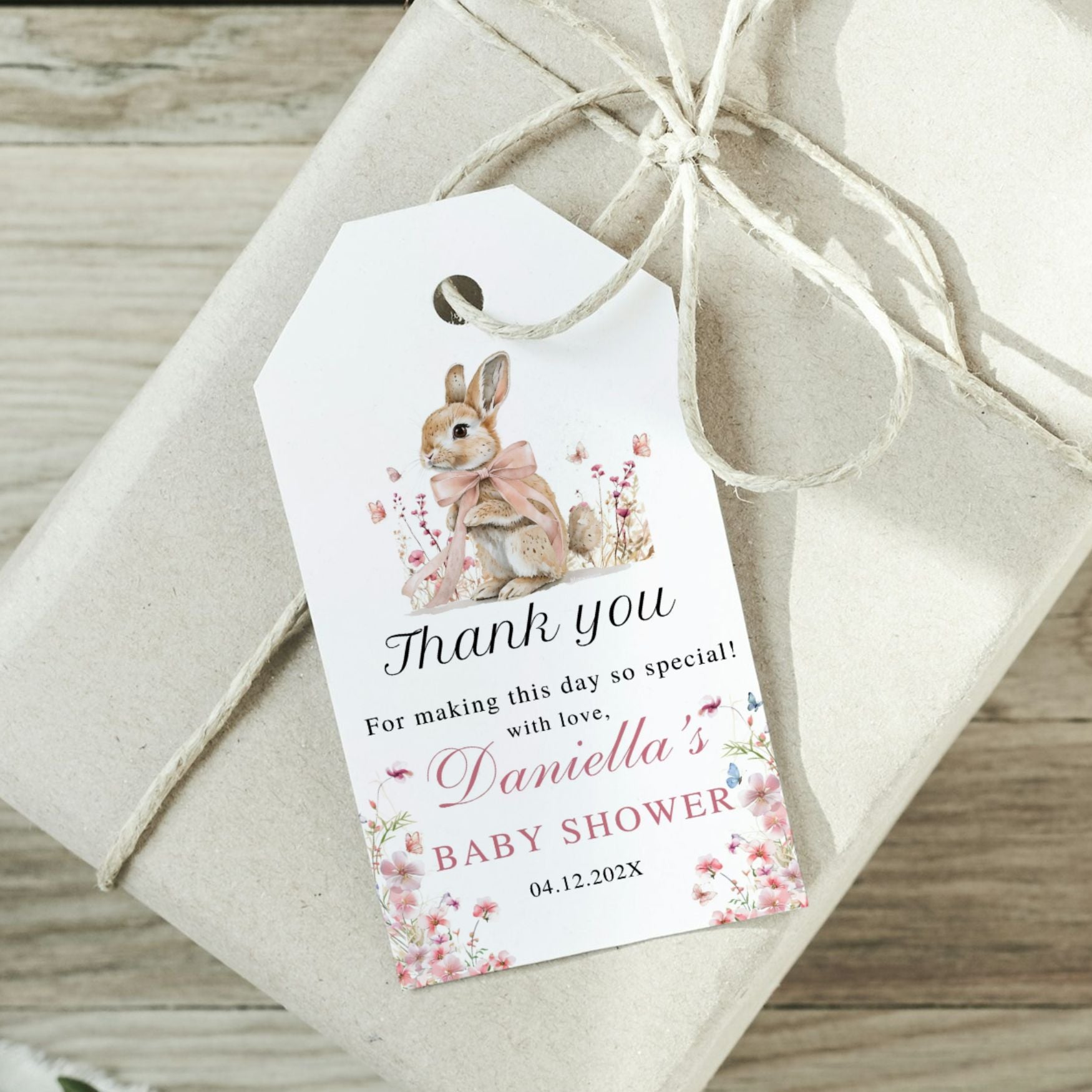 Gift tag with a rabbit illustration and baby shower message on a wrapped gift.