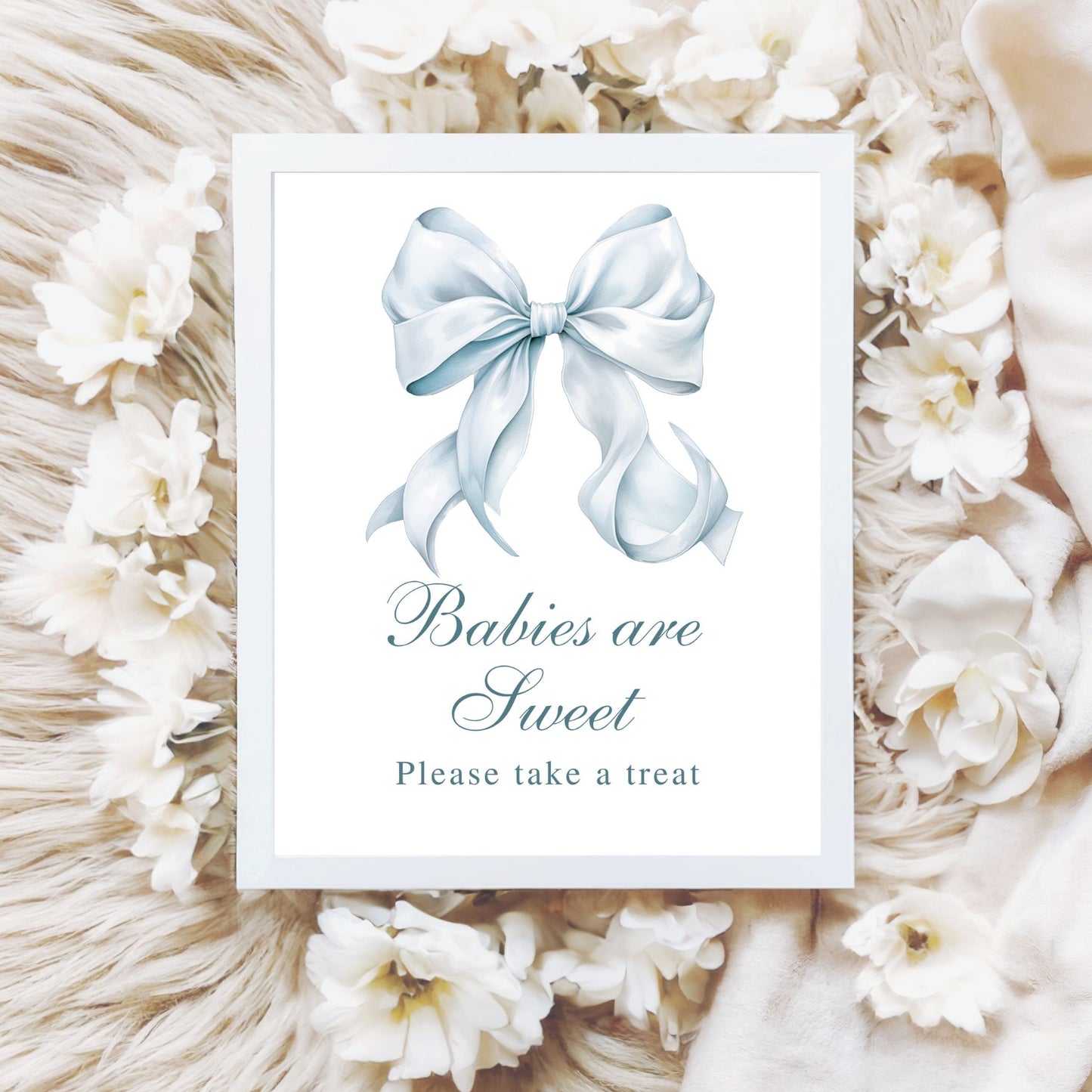 Framed picture with a blue bow and text 'Babies are Sweet Please take a treat' surrounded by white flowers and decorative elements.