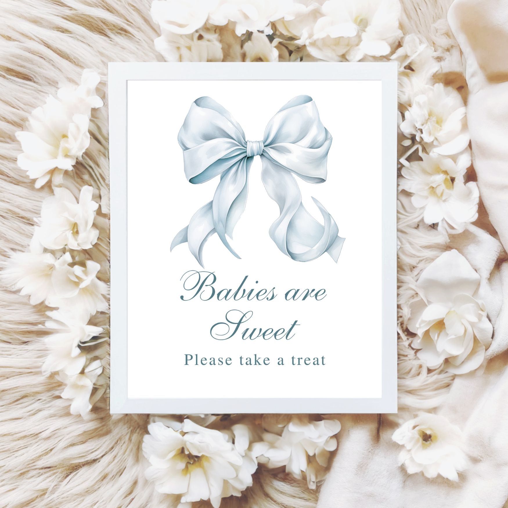 Framed picture with a blue bow and text 'Babies are Sweet Please take a treat' surrounded by white flowers and decorative elements.