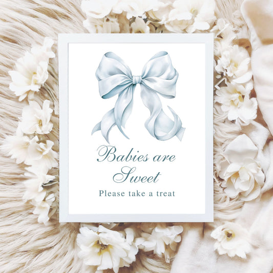 Framed picture with a blue bow and text 'Babies are Sweet Please take a treat' surrounded by white flowers and decorative elements.