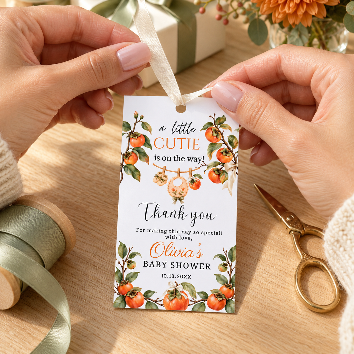A Little Cutie Persimmon Baby Shower Thank You Gift Tag in hands with watercolor design and ribbon, perfect for favors.