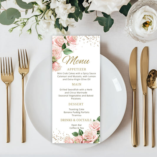 Menu card with pink floral design on a table setting with white plate, gold cutlery, and flowers.