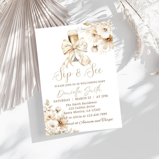 Invitation card for a baby shower with floral design and champagne glass on a white background.