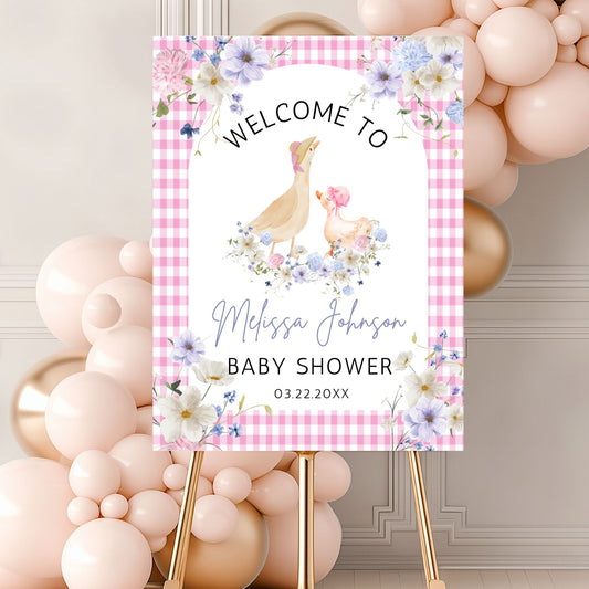 Baby shower welcome sign with chickens and flowers on a pink checkered background, surrounded by balloons.