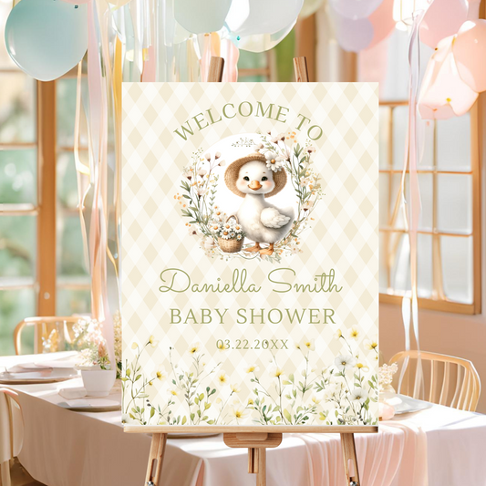 Baby shower welcome sign with a duck illustration and balloons in the background